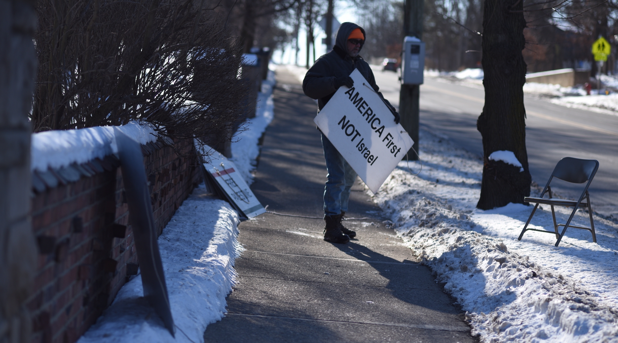 A protester stands outside Beth Israel Congregation in Ann Arbor, Michigan, in 2020. 