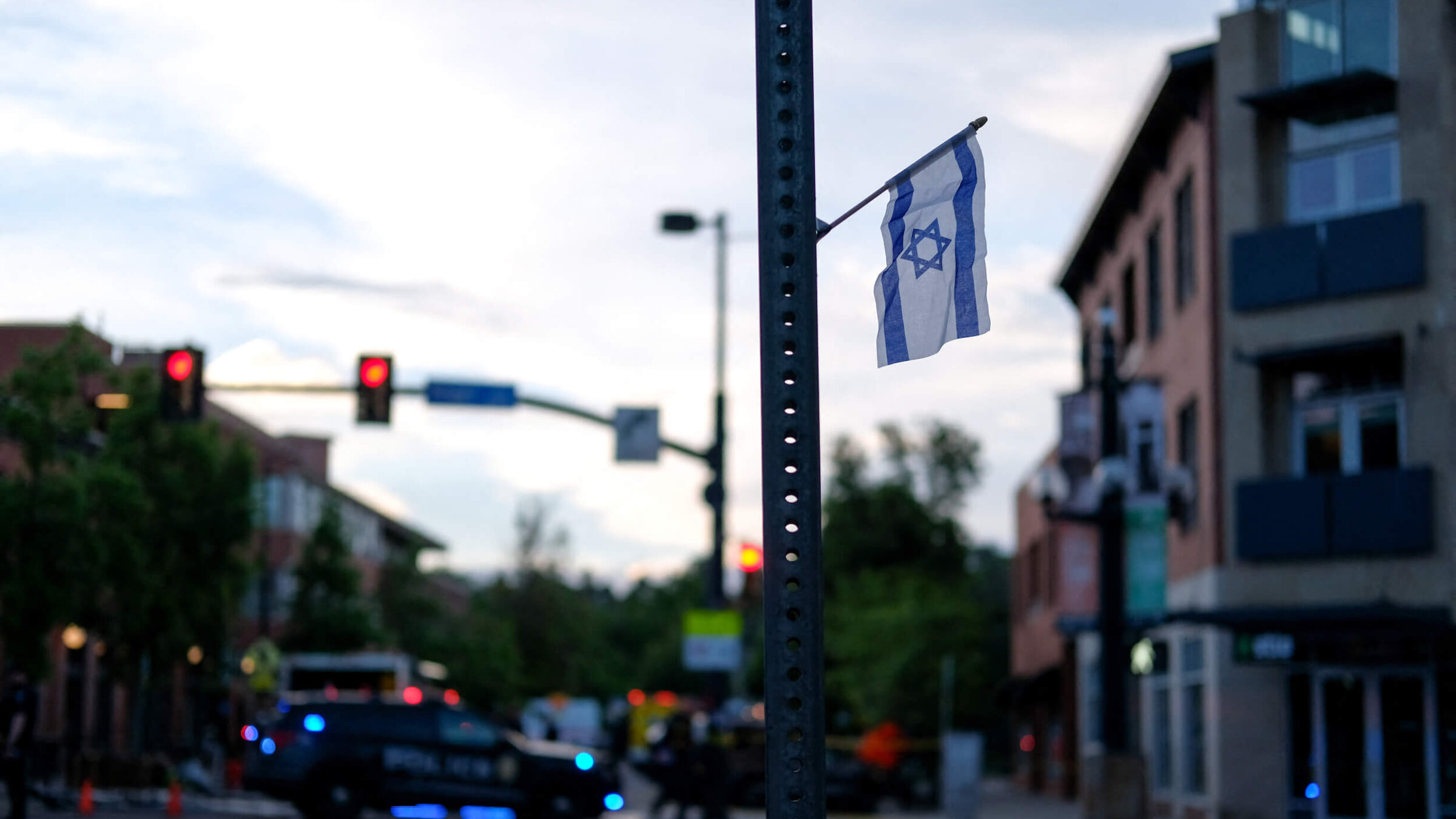 An Israeli flag is fixed to a street sign near Pearl Street in Boulder, Colorado, on the scene of a Sunday attack on demonstrators calling for the release of Israeli hostages held in Gaza.