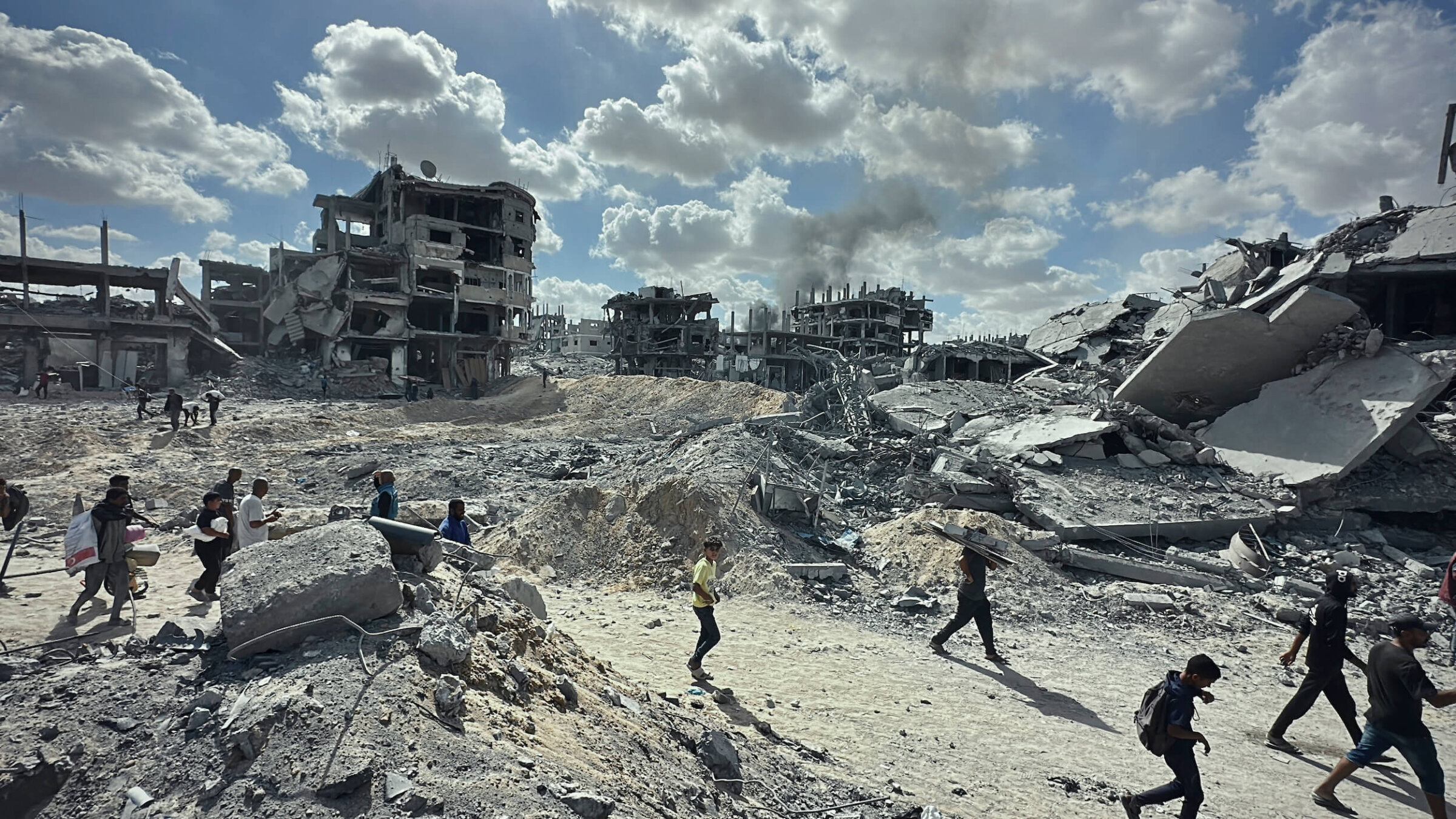 Palestinians walk among the rubble of destroyed buildings in Khan Yunis, in the southern Gaza Strip, on Oct. 10.