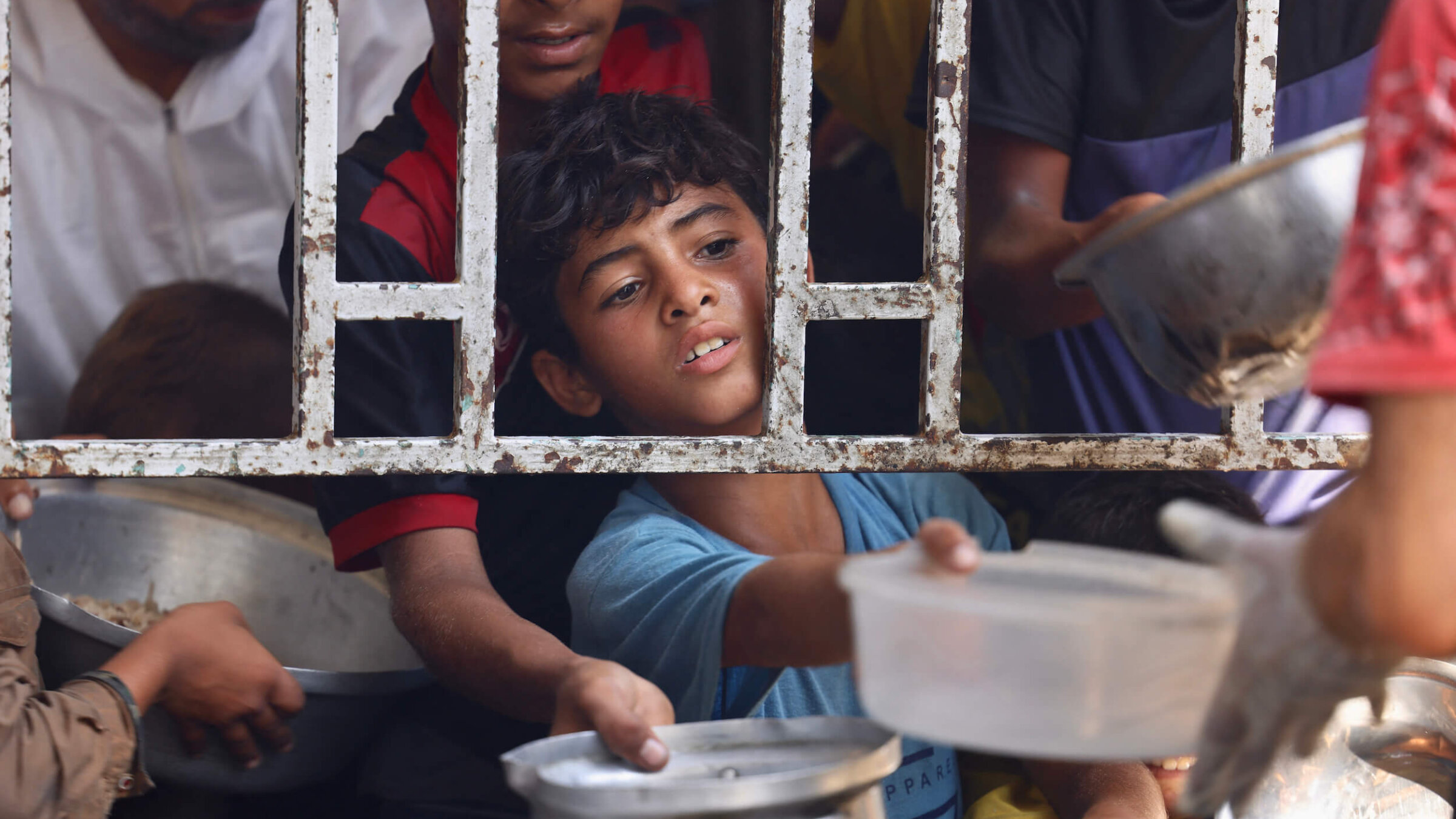 A Palestinian boy seeks a cooked meal at a charity kitchen in the Mawasi area of Khan Yunis in the southern Gaza Strip on July 22.