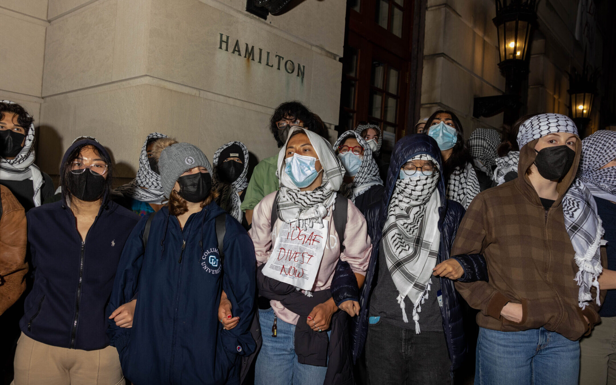 Student demonstrators lock arms to guard against potential authorities reaching fellow pro-Palestinian protesters who barricaded themselves inside Hamilton Hall at Columbia University.