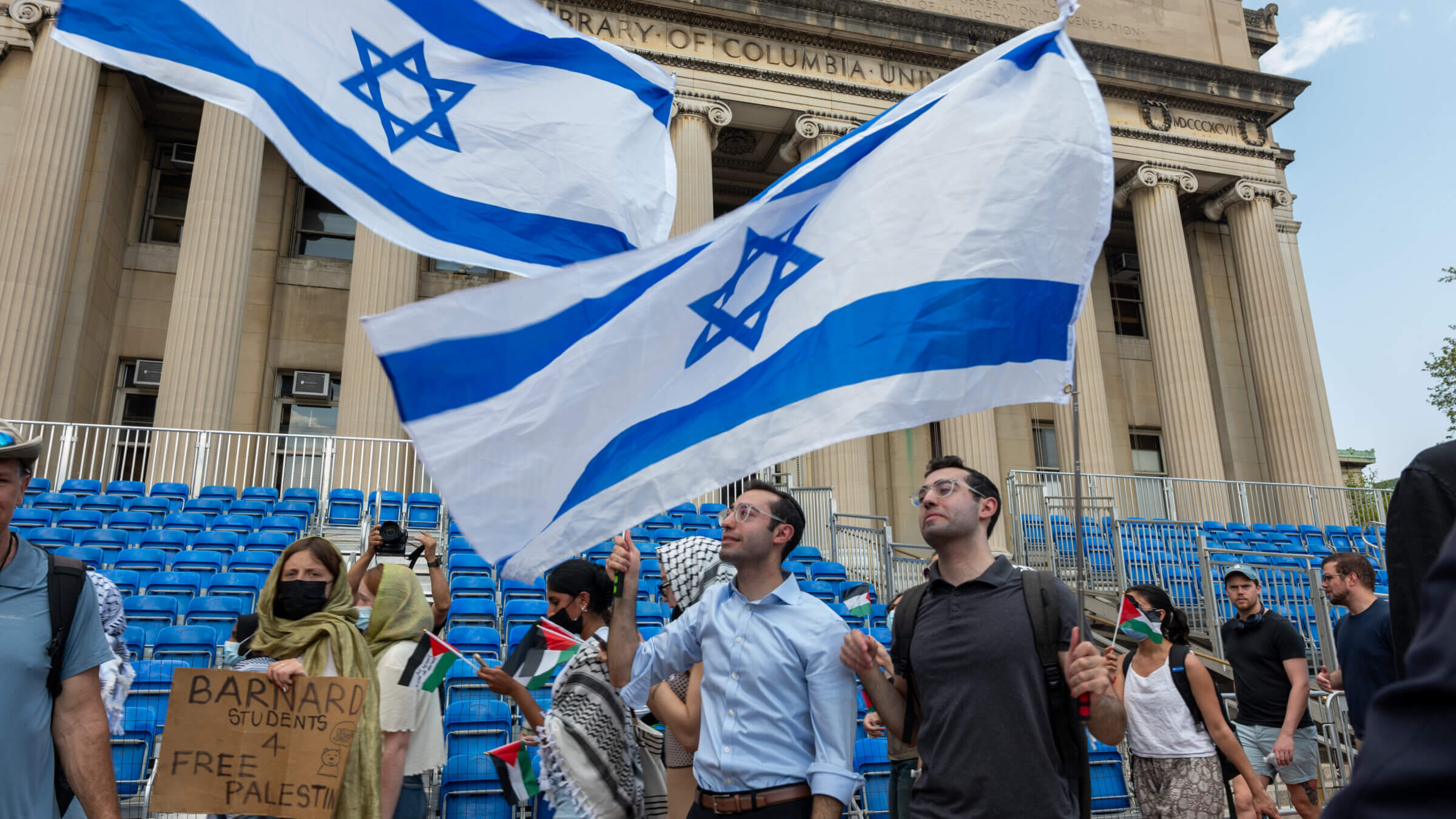 Men wave an Israeli flag as pro-Palestinian supporters continue to demonstrate from a protest encampment on the campus of Columbia University in April 2024.