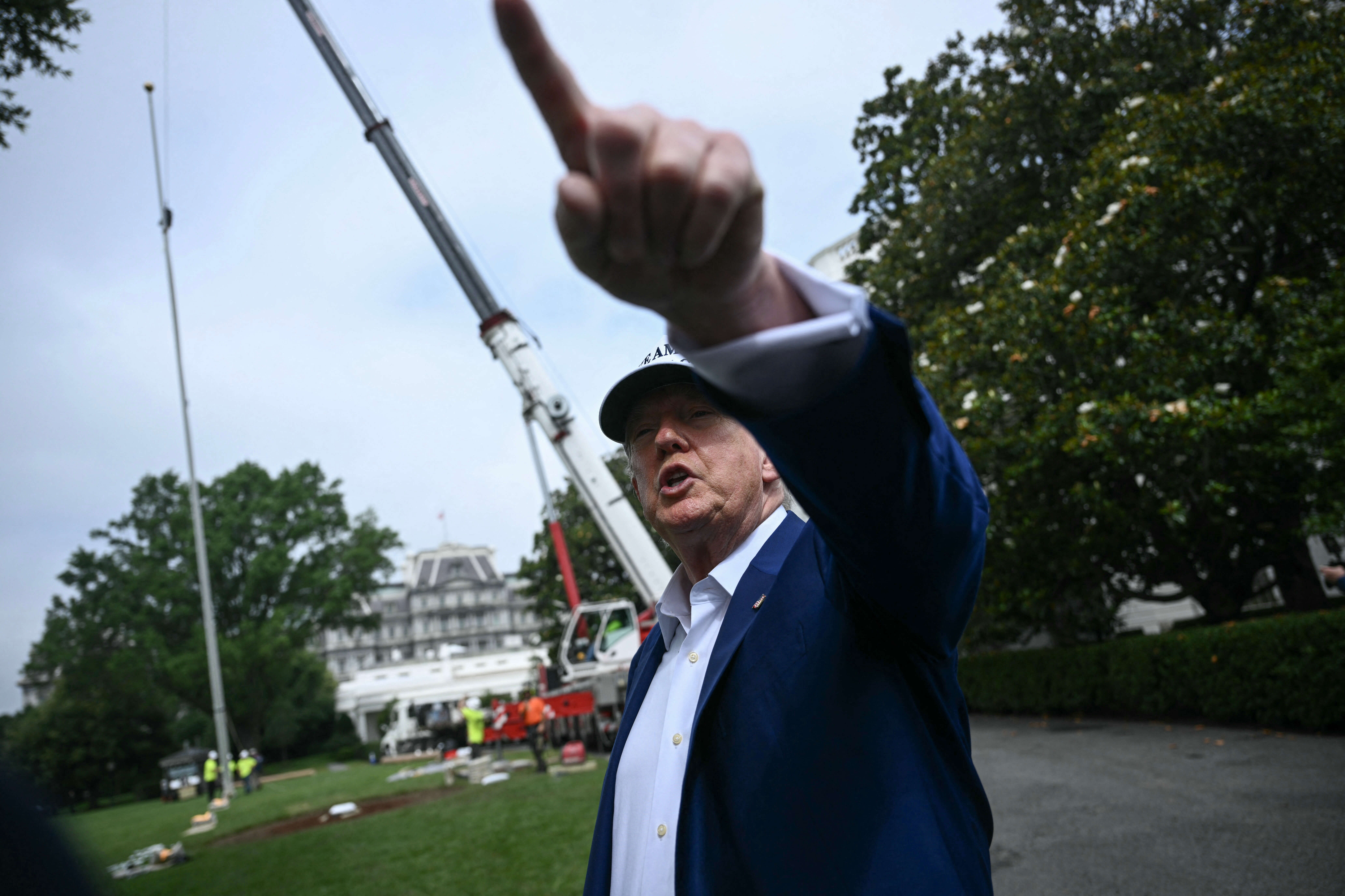 Donald Trump observes the installation of a flag pole.