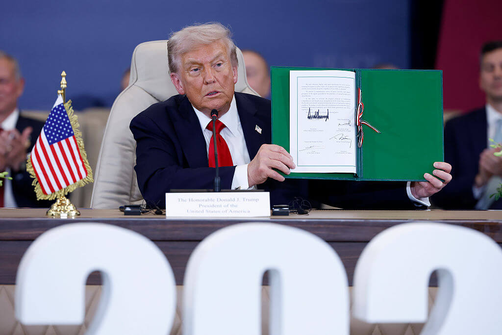 President Donald Trump holds up a signed agreement at a "peace summit" in Egypt. 