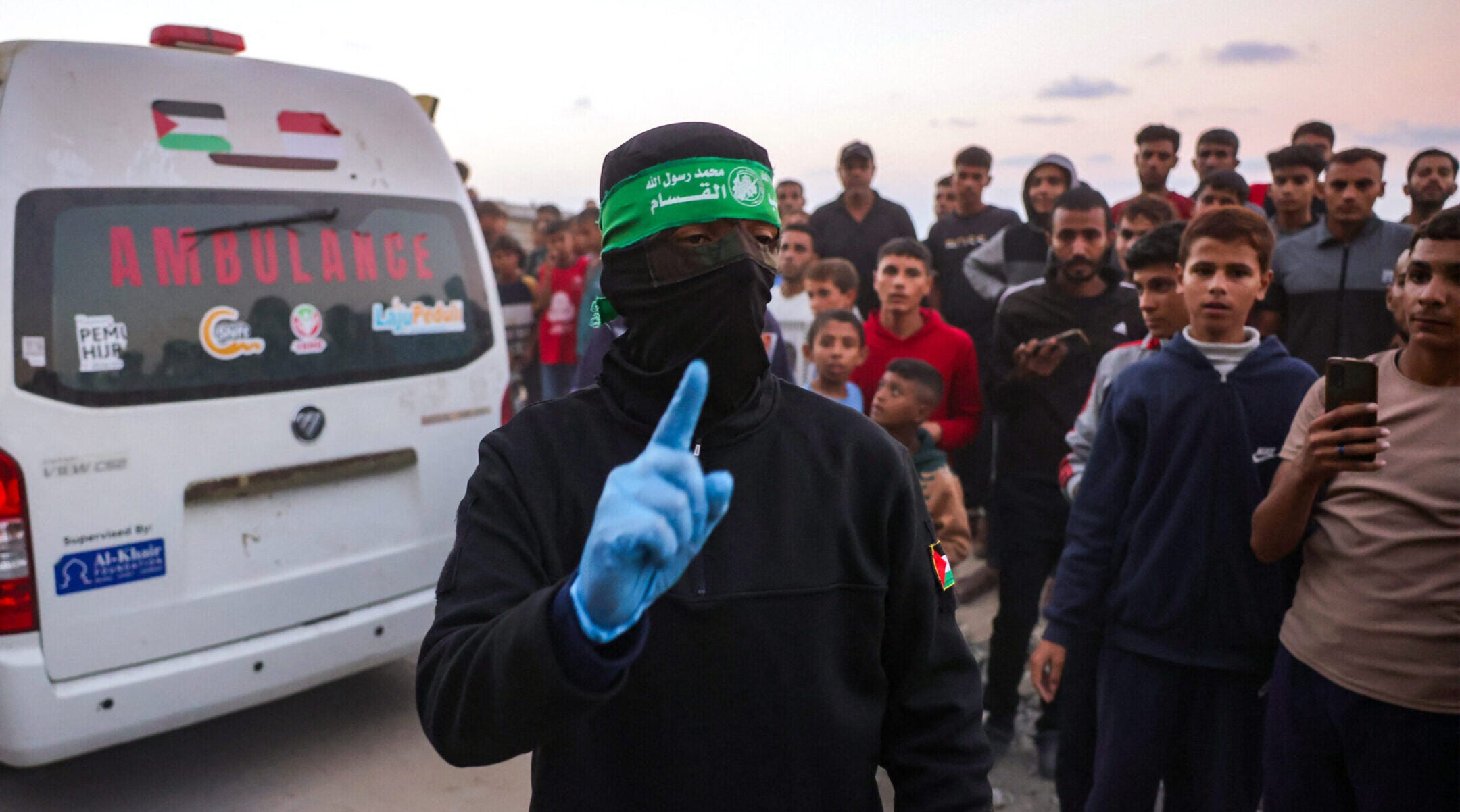 A Hamas member gestures as people gather around an ambulance carrying a body retrieved from a tunnel in an area north of Khan Yunis in Gaza on Oct. 28.