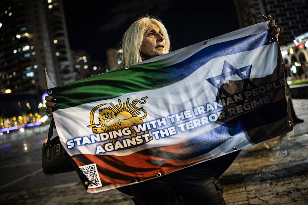 A woman holds a banner during a demonstration in solidarity with Iranian protestors in the Israeli city of Holon on January 14, 2026.