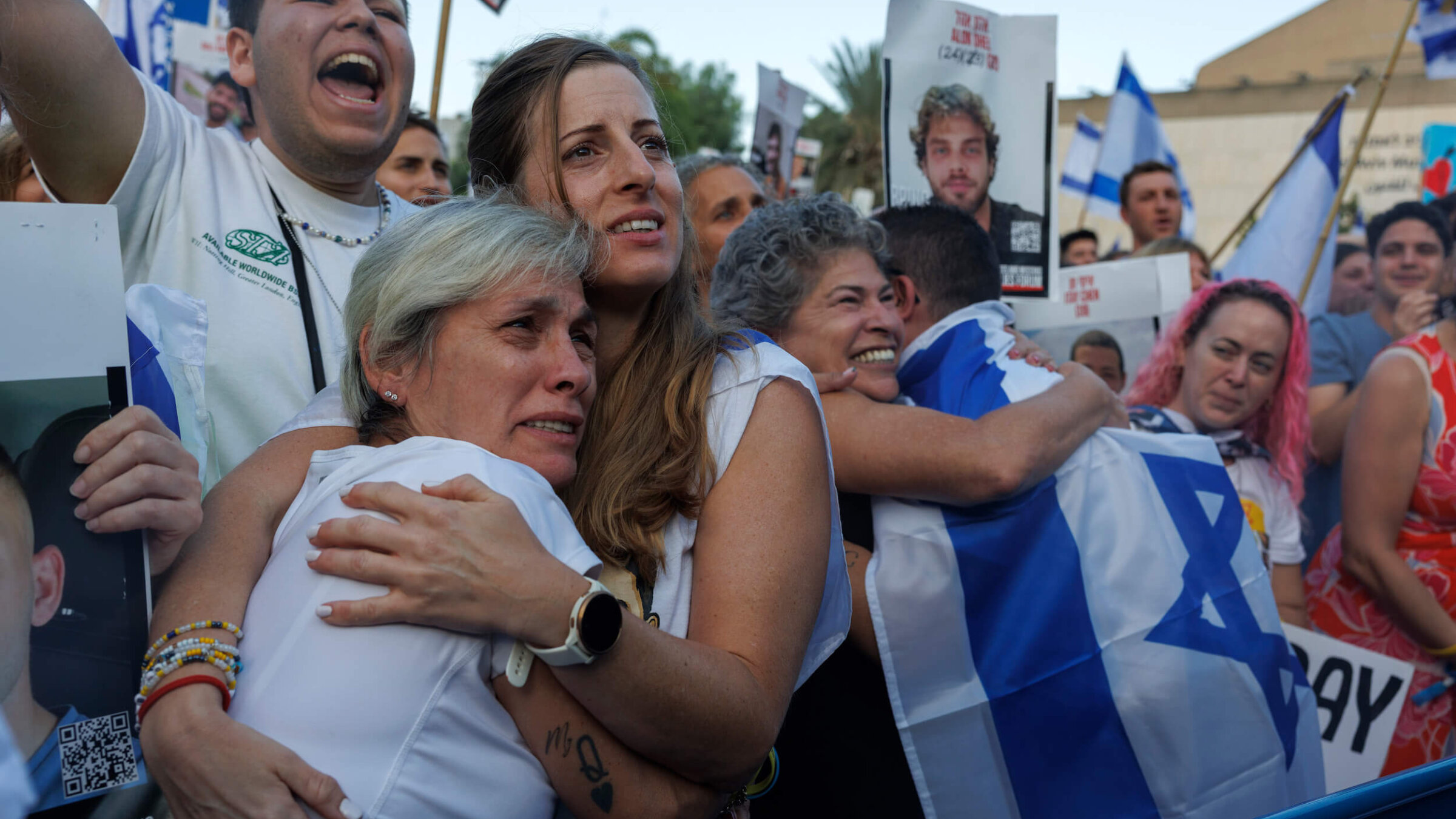 Israelis react as they watch the release of Israeli hostages by Hamas during a live broadcast in Tel Aviv Oct. 13.