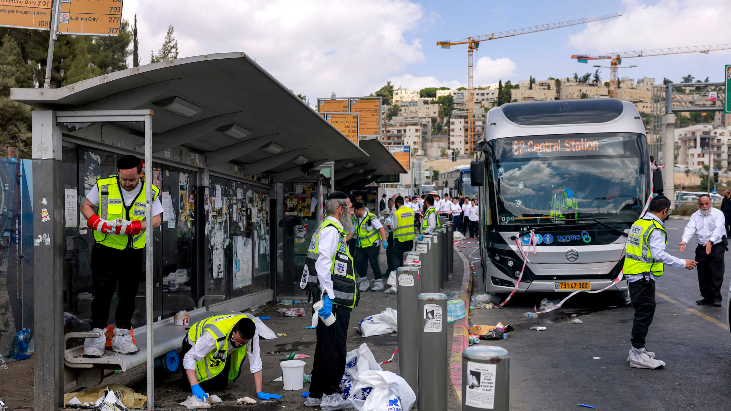 Members of Israel's ZAKA search and rescue emergency services collect samples at the scene of a shooting at the Ramot road junction in Jerusalem on Sept. 8.