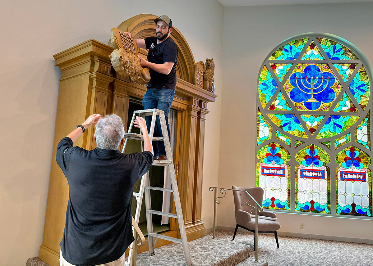 Nik Jakobs, on ladder, disassembling the ark at Temple B'nai Israel in White Oak, Pennsylvania, and handing a piece to Dick Leffel, a past president of the shul.