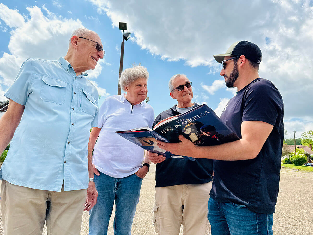 From left: Longtime Temple B'nai Israel members Lou Anstandig, Steve Mayer, and Dick Leffel chat with farmer Nik Jakobs in the parking lot.