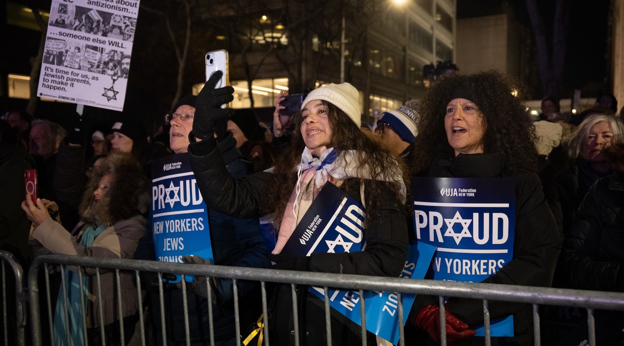 Rally-goers held signs distributed by UJA-Federation of New York, and braved the 30-degree weather outside Park East Synagogue, Dec. 4, 2025. 