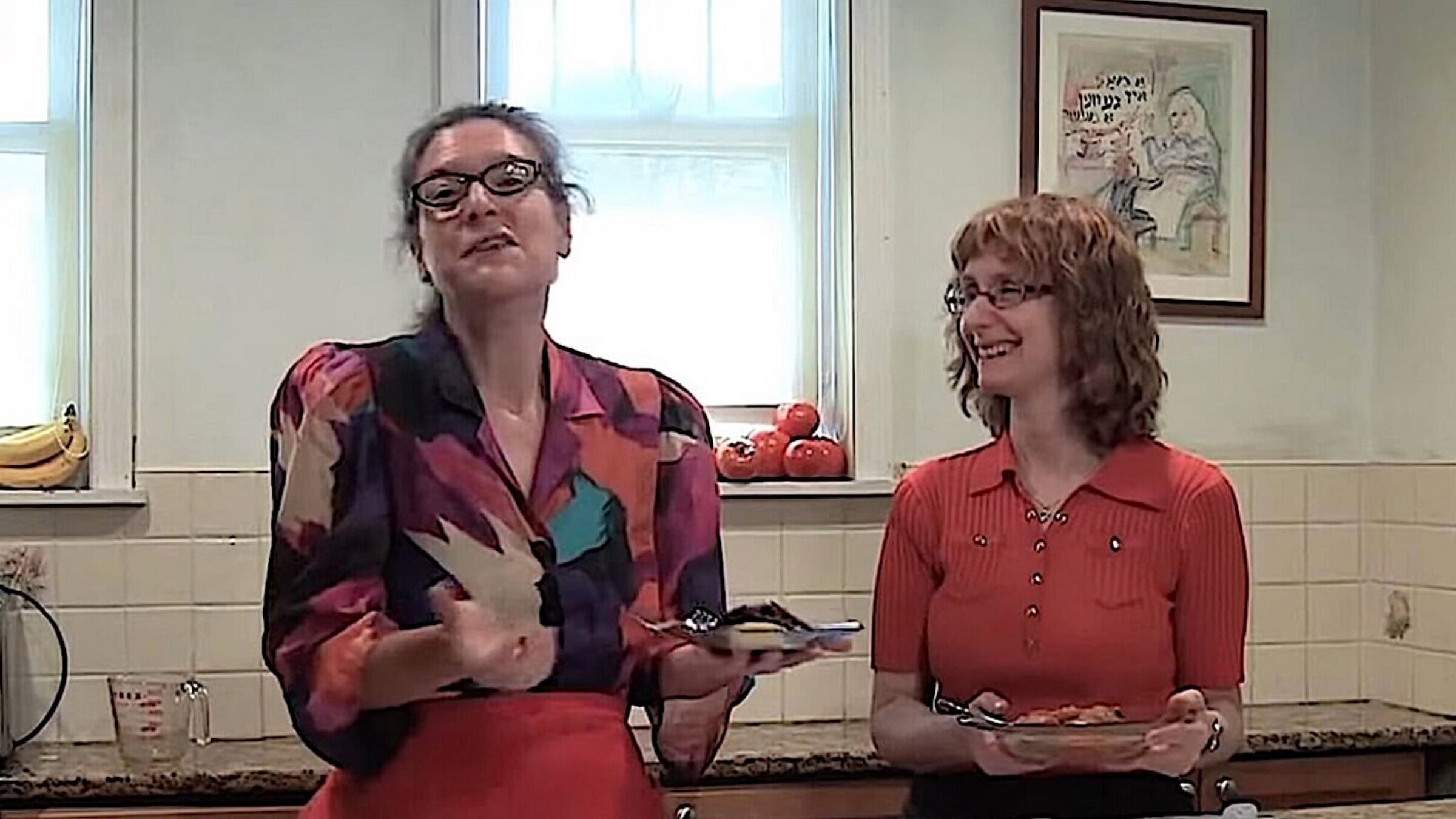 Eve Jochnowitz (left) and Rukhl Schaechter demonstrating how to make tzimmes, on their cooking show, "Est Gezunterheyt" ("Eat in Good Health")