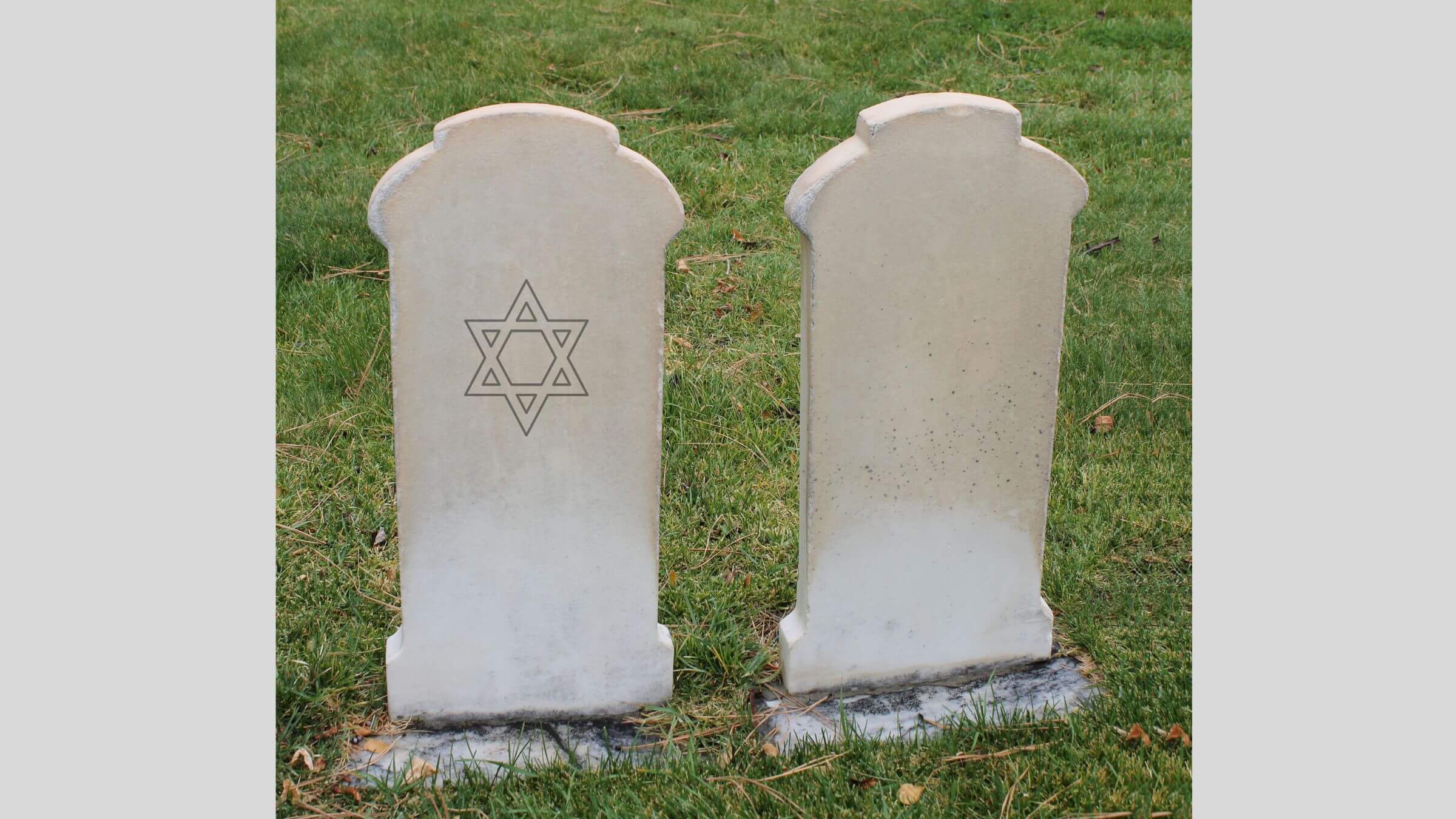 A gravestone with a Star of David next to an unmarked stone.